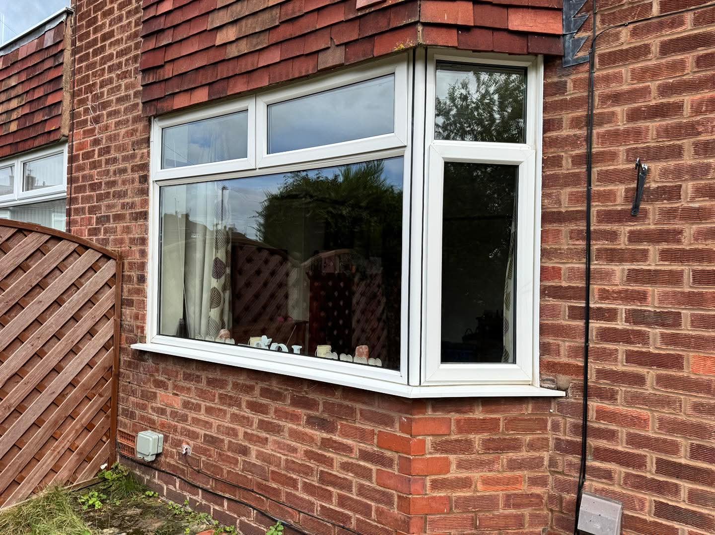 Clean white-framed bay window on a brick Hereford home