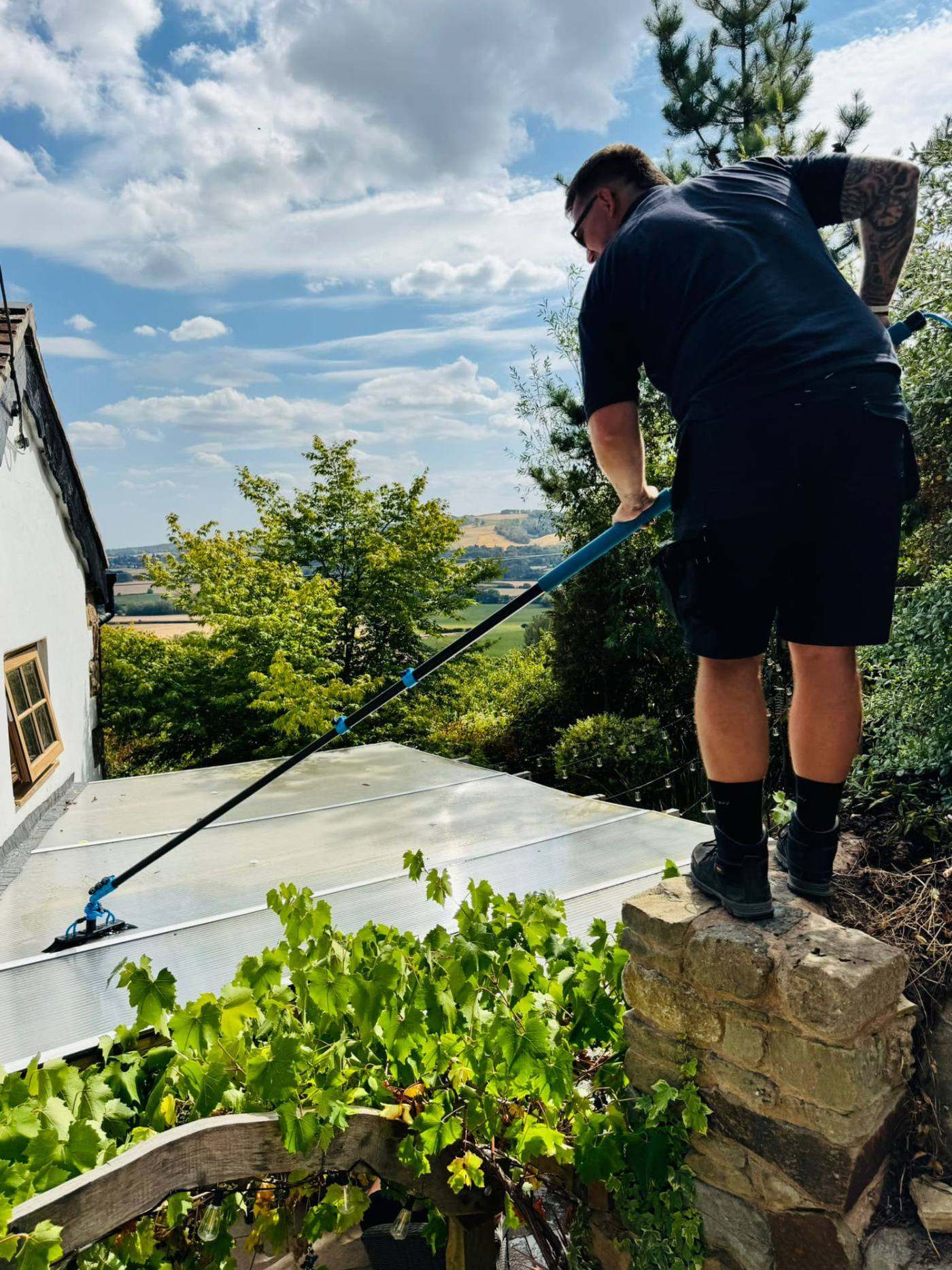 Lofty Cleans operative cleaning a conservatory roof with a water fed pole