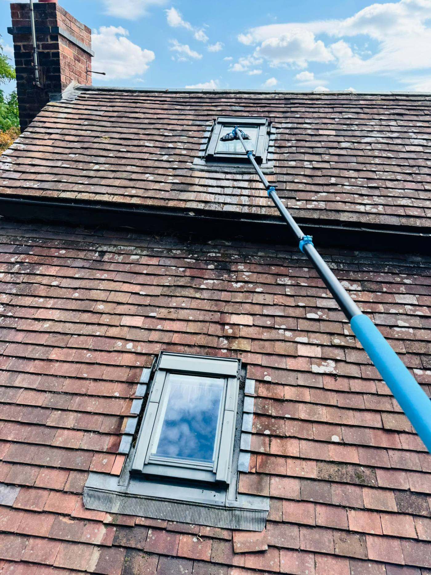 UK tiled house roof with moss growth between the tiles