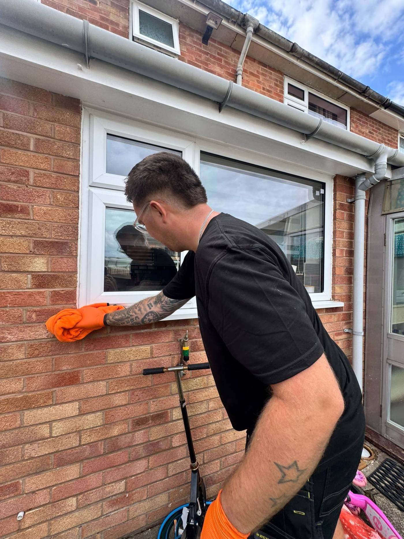 Cleaning a window pane by hand with a squeegee